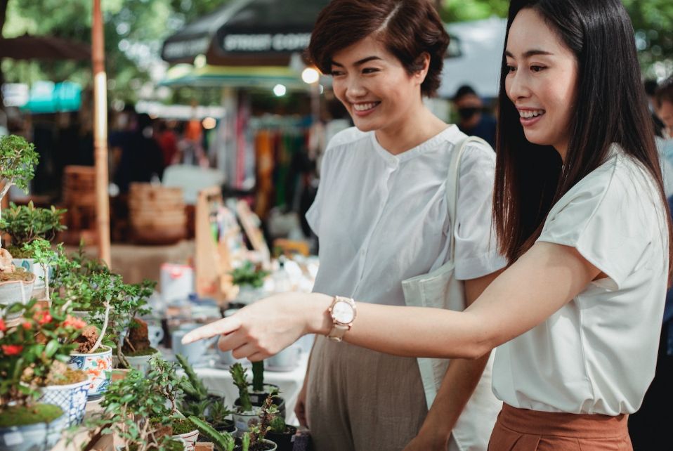 Two women pointing at new plants for sale