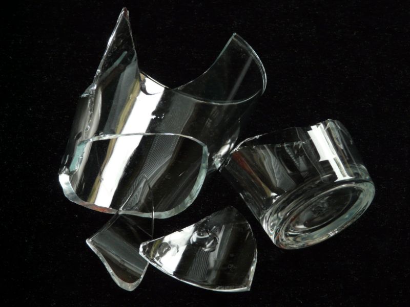 A broken drinking glass in several large pieces