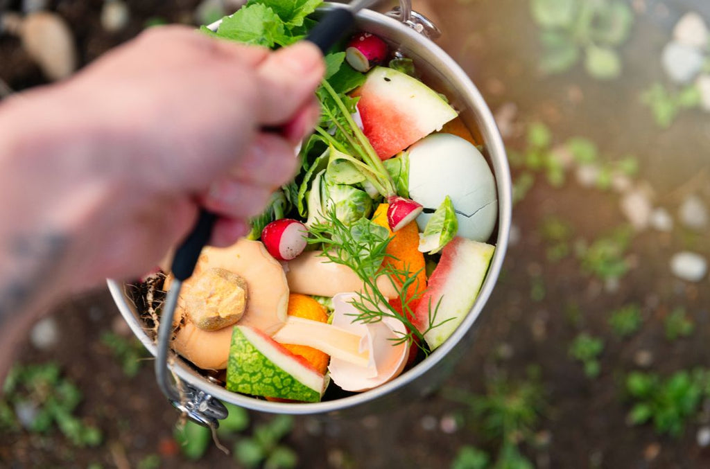 A silver bucket filled with a variety of food waste