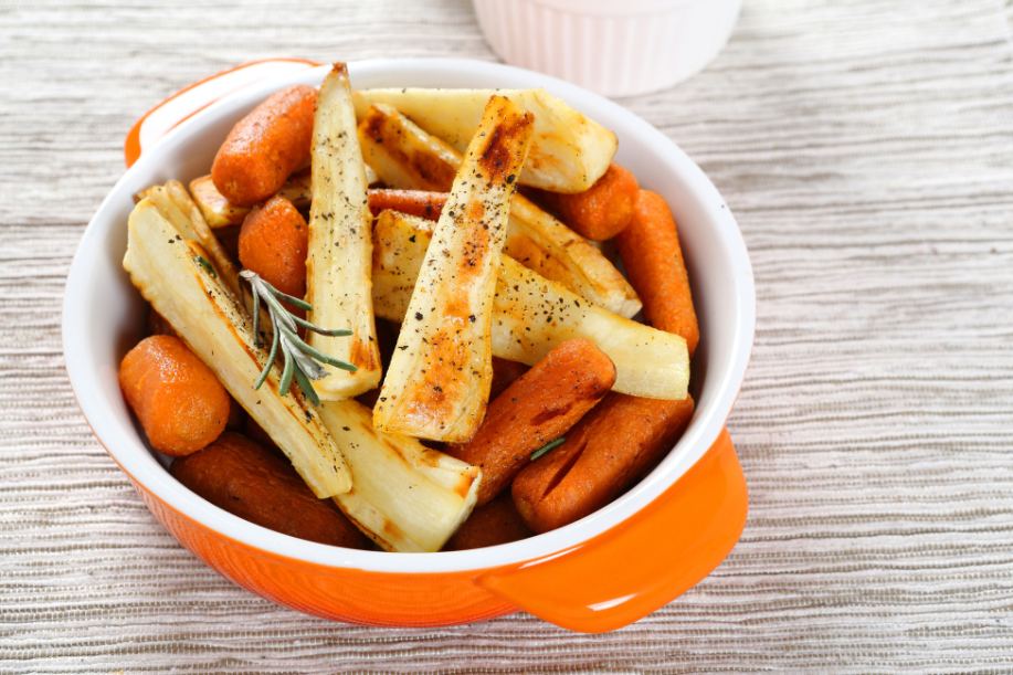 A bowl filled with cooked carrots and parsnips