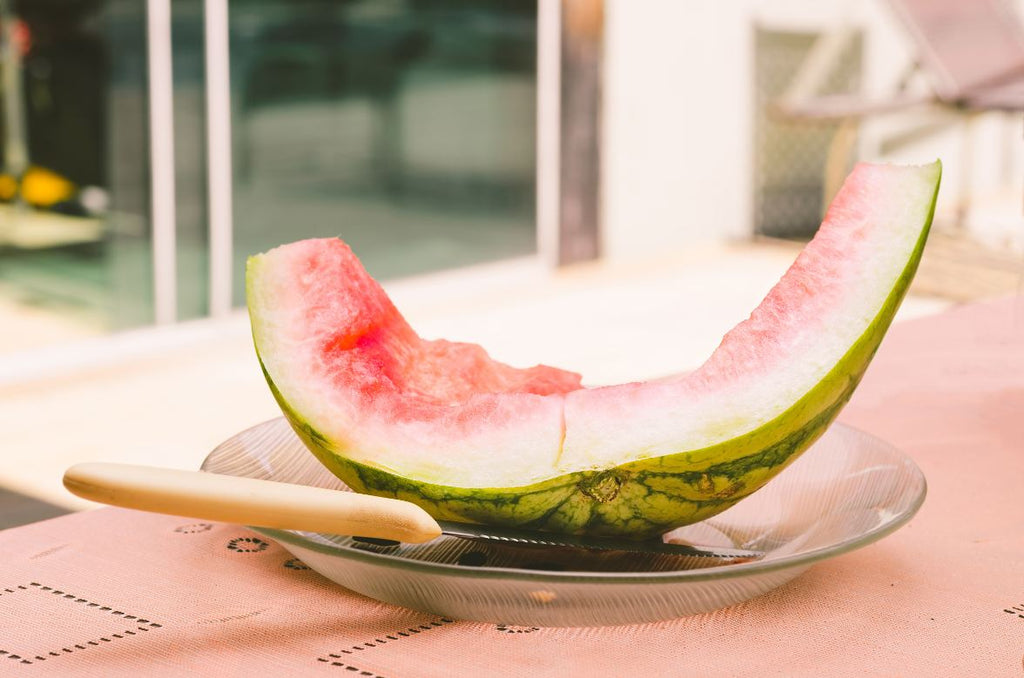 A watermelon rind on a plate with a knife