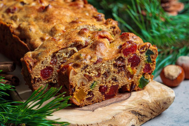 Sliced fruitcake on a wooden cutting board