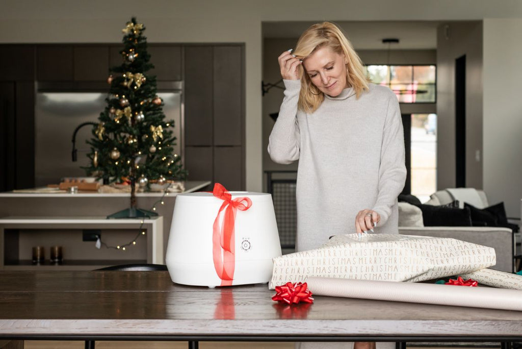 woman with Lomi and bow wrapping gifts