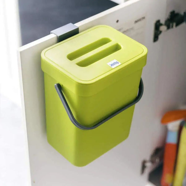 green compost bin hanging inside cabinet