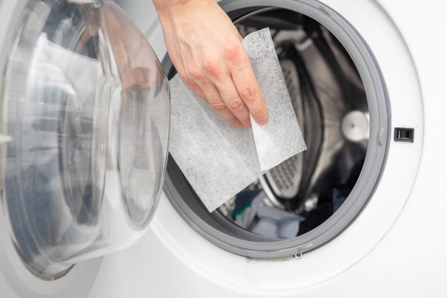 Putting a single dryer sheet into a drying laundry machine