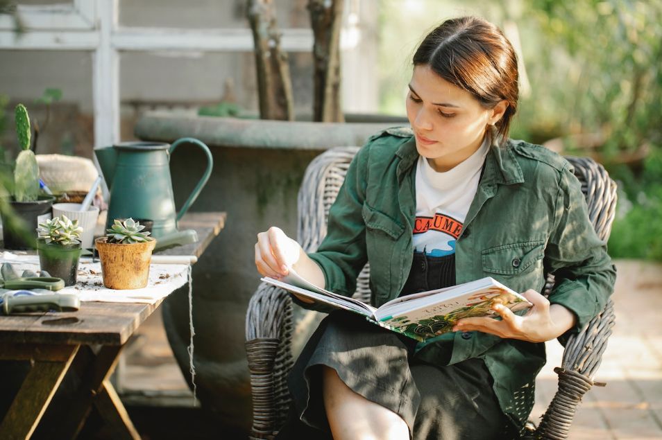 Young woman reading gardening book