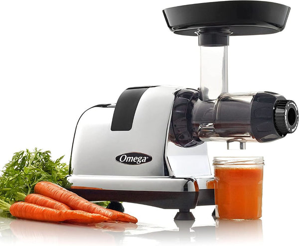 Silver juicer with carrot juice and carrots