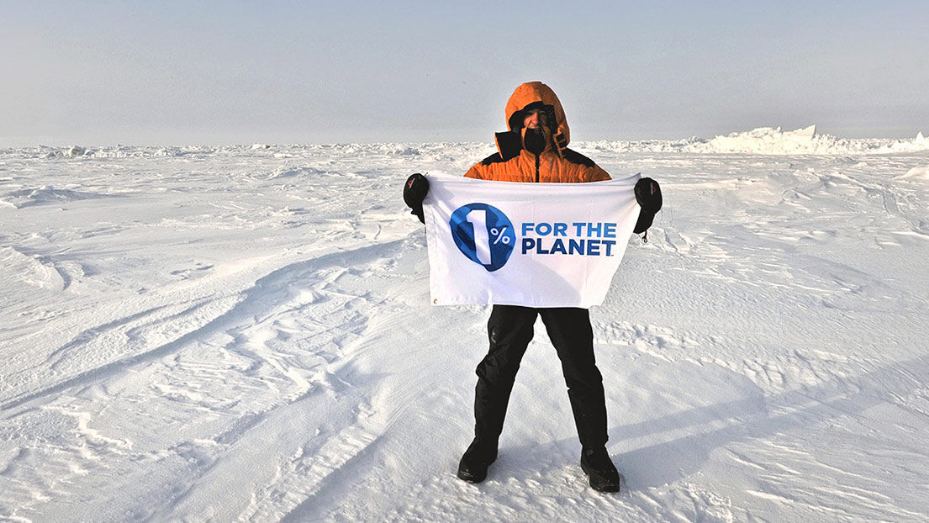 A man holding a flag that says 1% for the planet