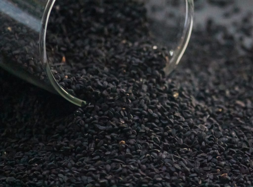 Black onion seeds poured from a jar