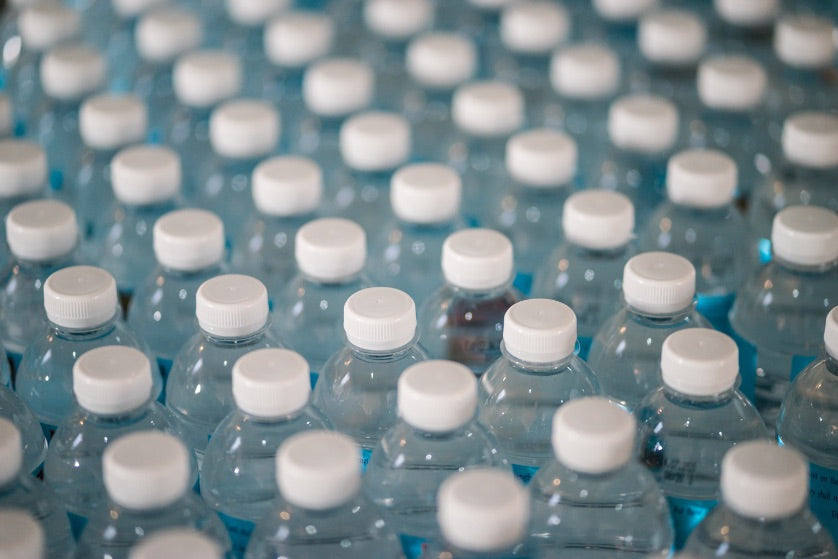 Many water bottles lined up right beside each other