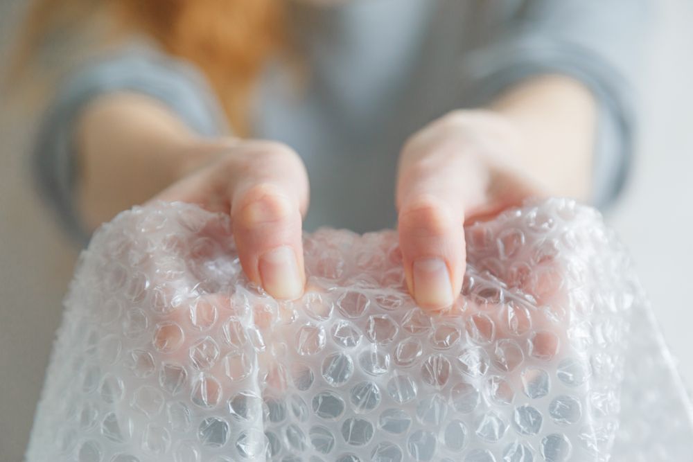 Hands popping some bubble packing material