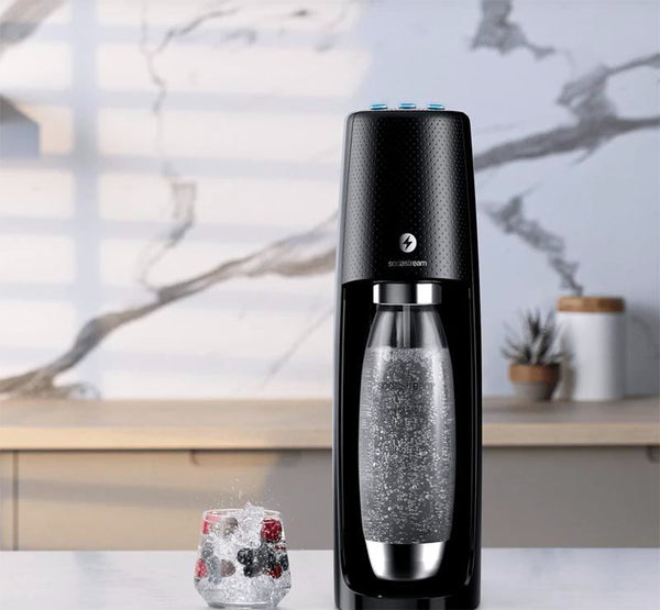 A black soda machine with a fizzy drink next to it