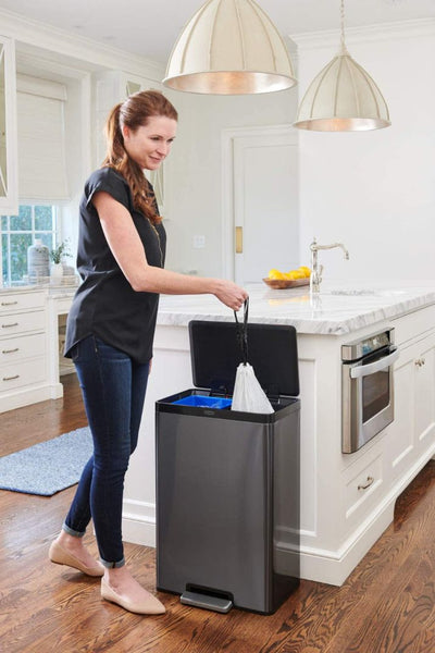 person pulling a trash bag out of trash can