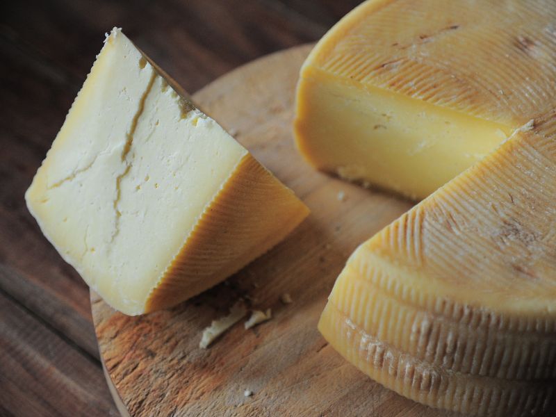 A wheel of cheese with a slice taken out of it