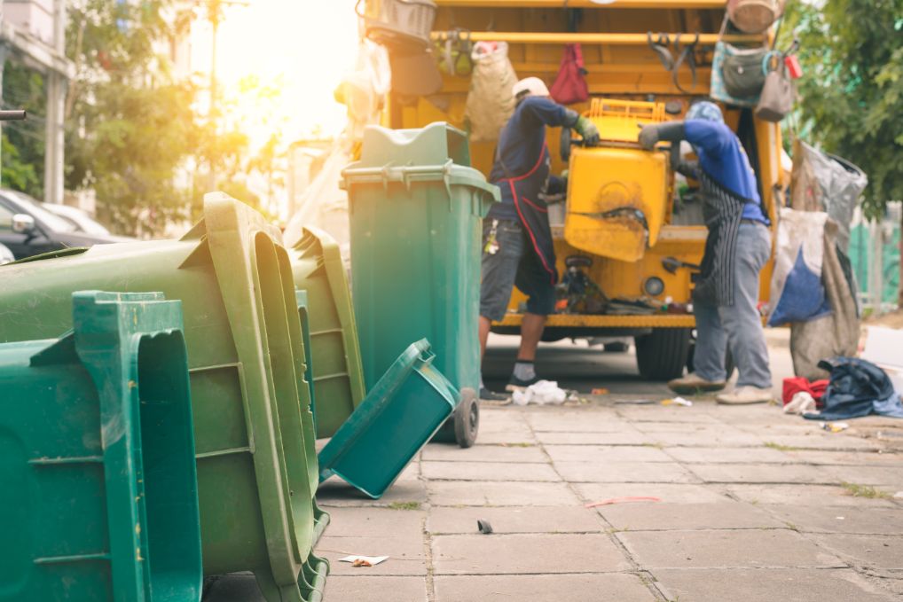 Garbage collectors emptying bins into the truck