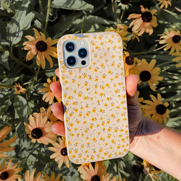 person holding a phone case with small yellow flowers on it