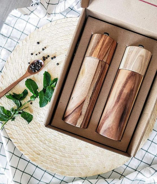 A wood salt and pepper shaker set in a cardboard box