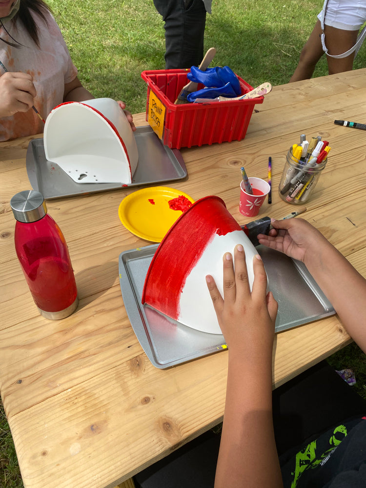 Students paint their Sead Pod vertical garden planters as a part of a school project