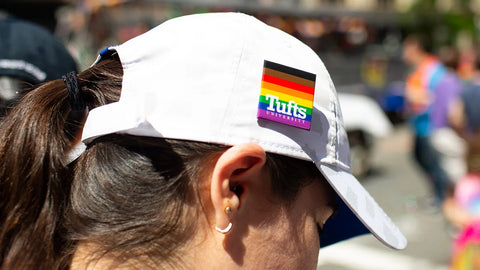 woman wearing white hat with rainbow lgbt Tufts University Pride Pin