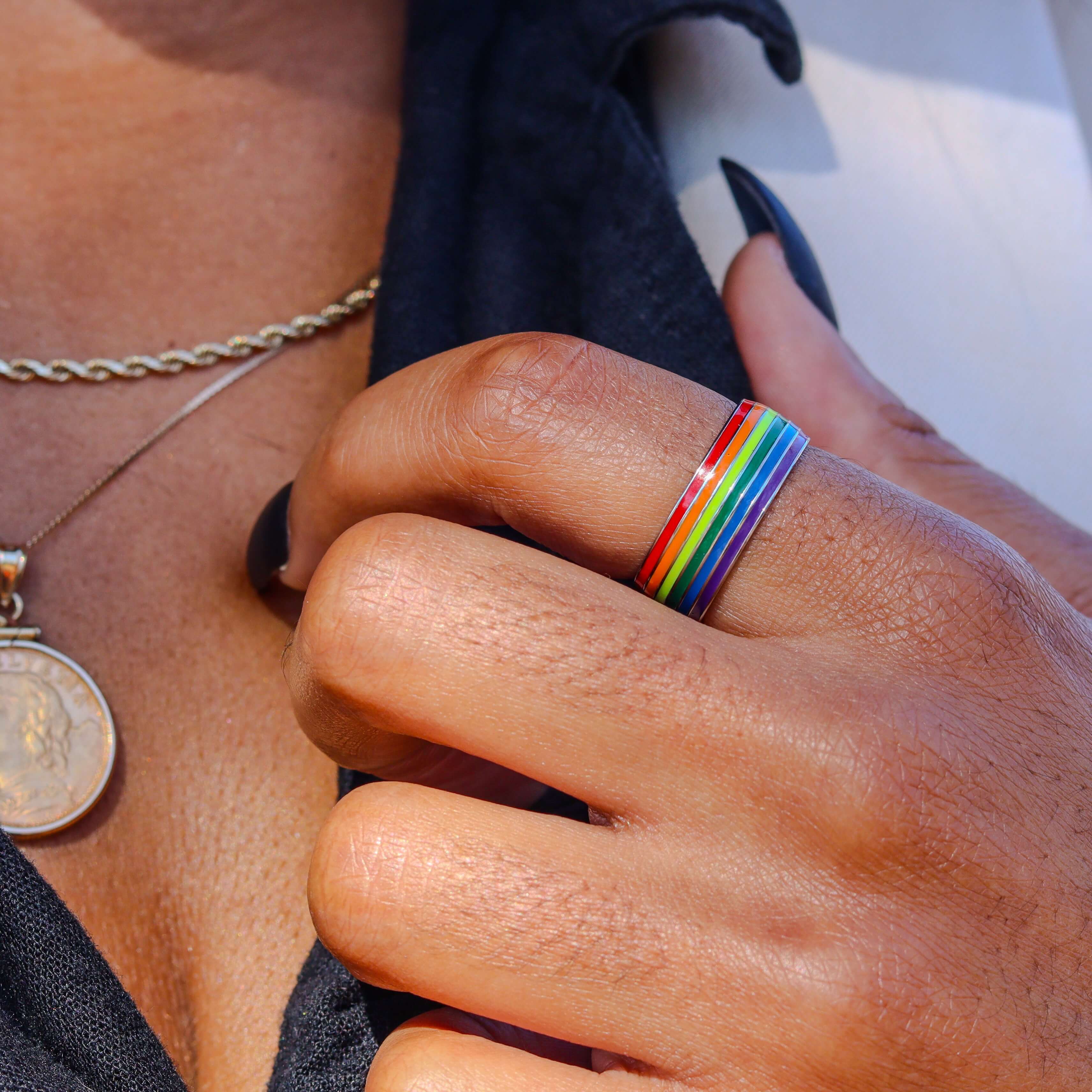 Girl wearing gold rainbow gay pride ring on her index finger