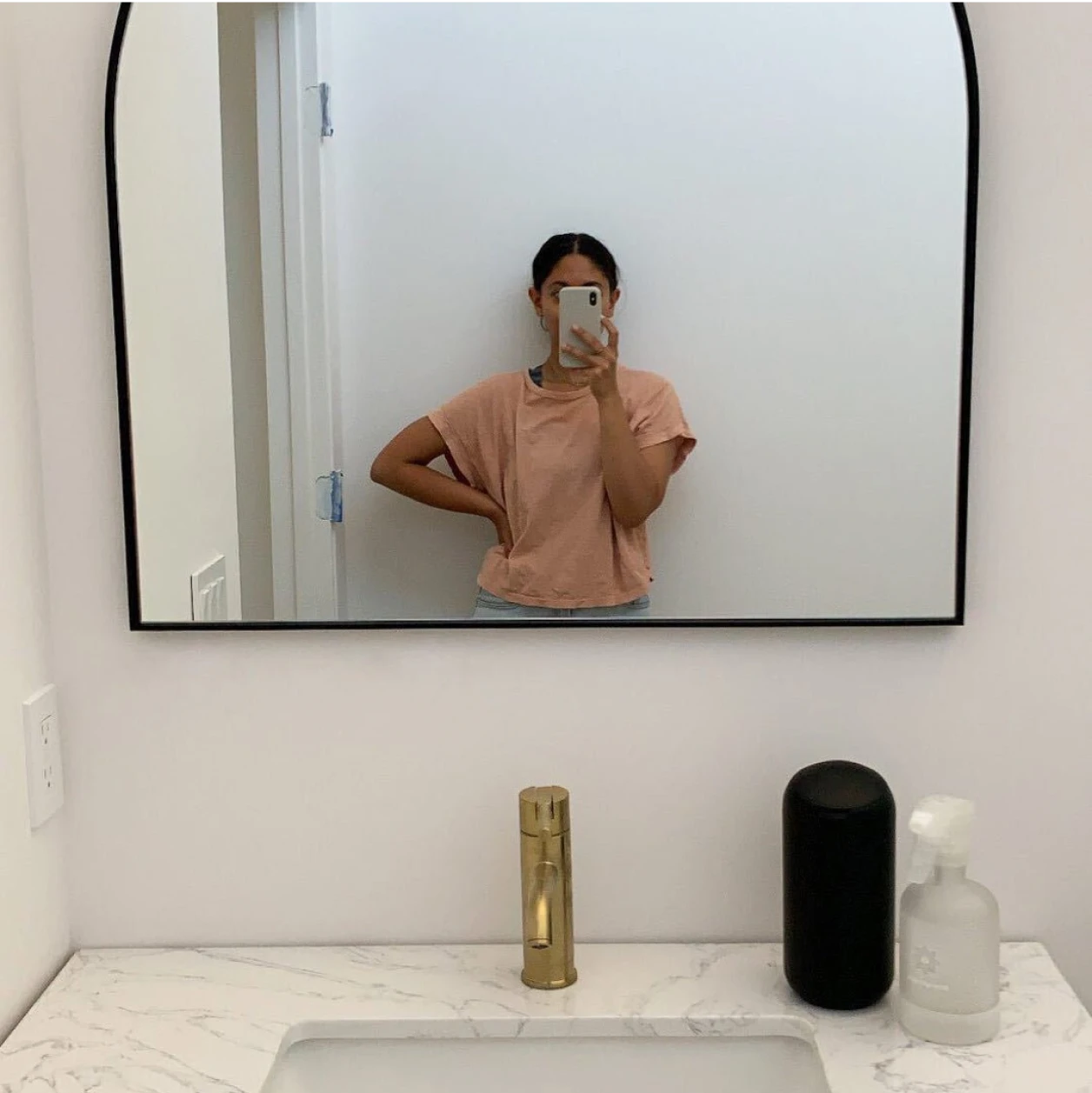 Person taking a mirror selfie in a bathroom.