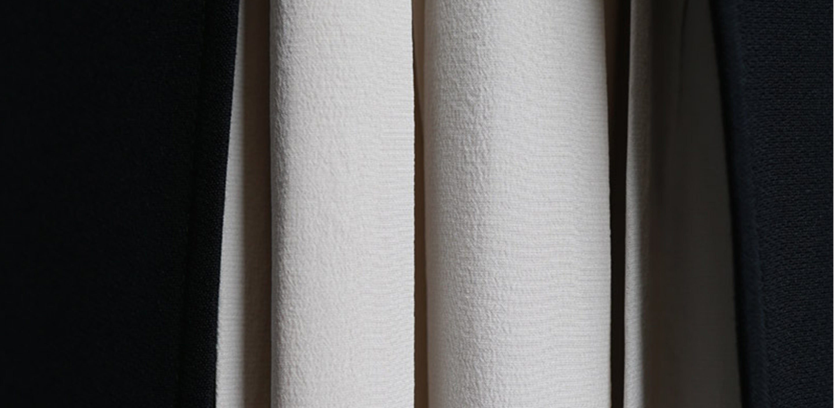 Zoom in on the pleats of a cream-colored garment