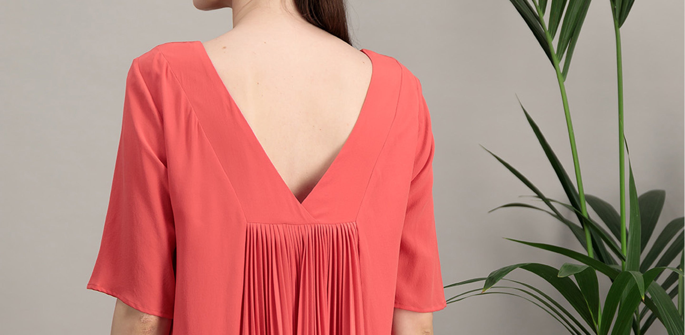 dress in coral pleated silk crepe and short sleeves