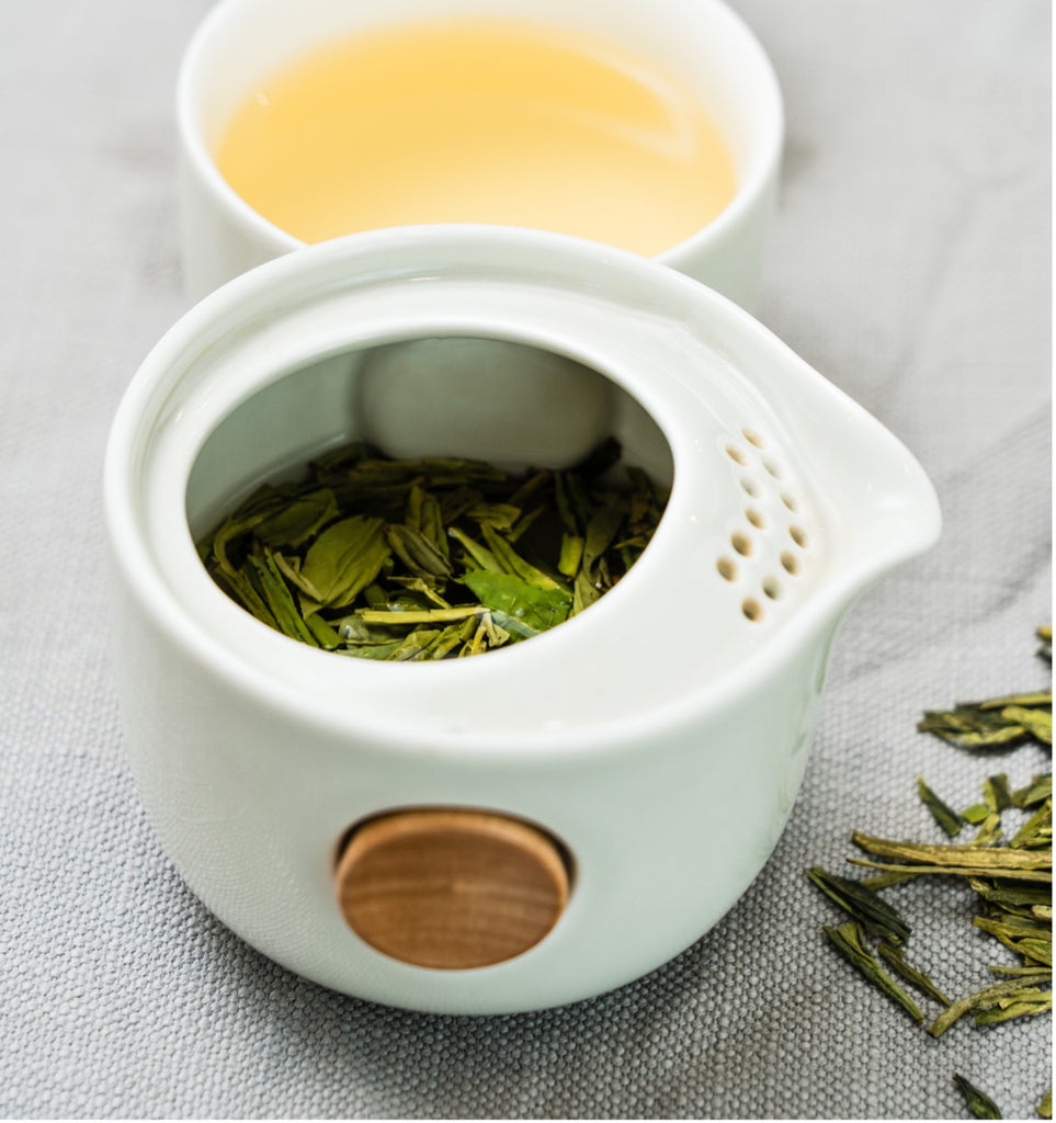 Green Tea Leaves inside white porcelain gaiwan