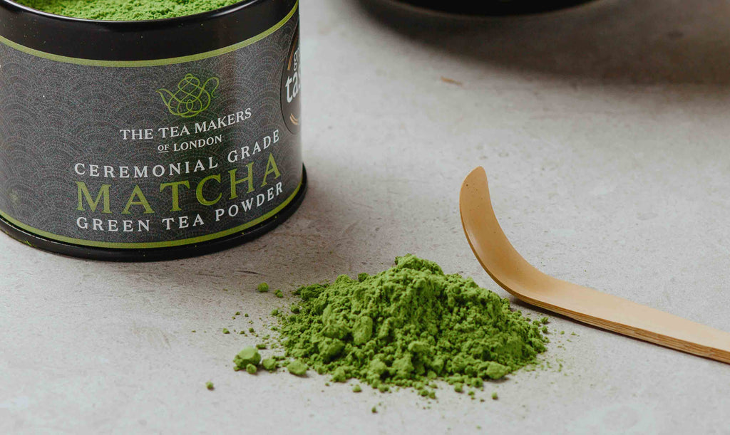 Green Matcha Powder with wooden spoon and black metal caddy