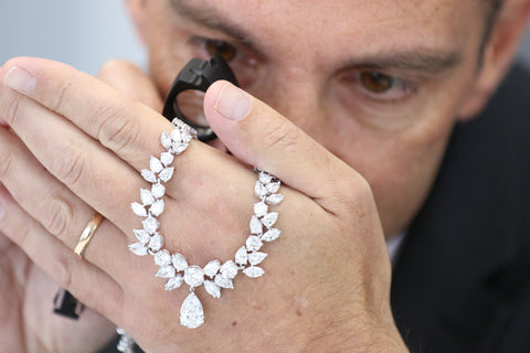 man inspecting jewelry