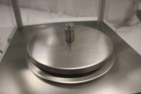 Small Calibration Weight on a Weighing Pan