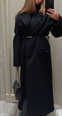 fille prenant un selfie dans un manteau noir avec un sac Chanel