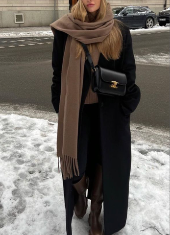 girl in the snowy street with a black coat, boots, a brown scarf and a black celine triomphe bag