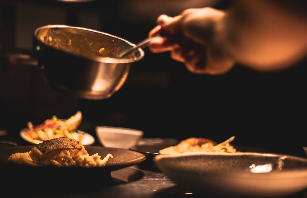 Chef cooking a variety of foods in a pizza oven