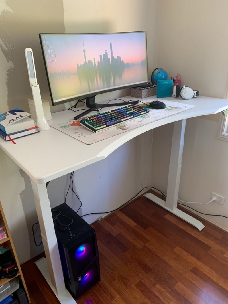 A curved monitor on a standing desk