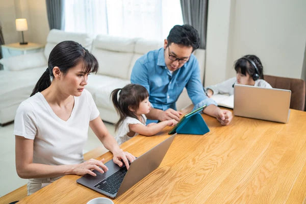 parents working from home with kids studying on the same workstation