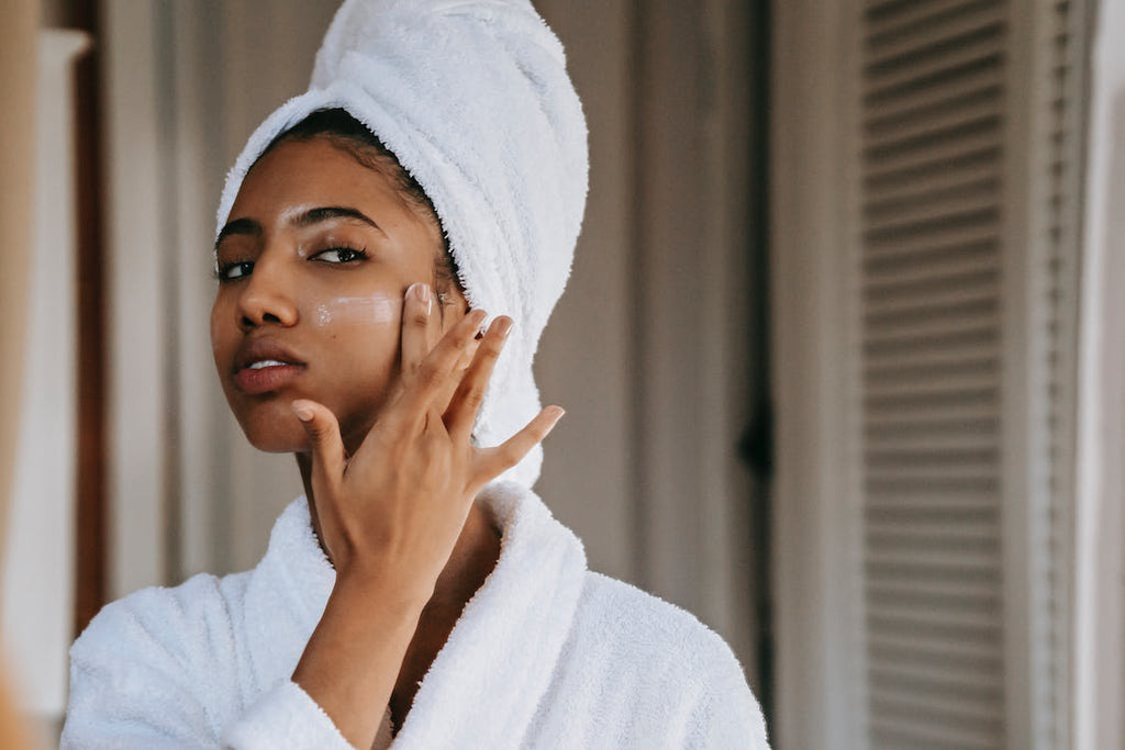 woman applying skin cream to cheek