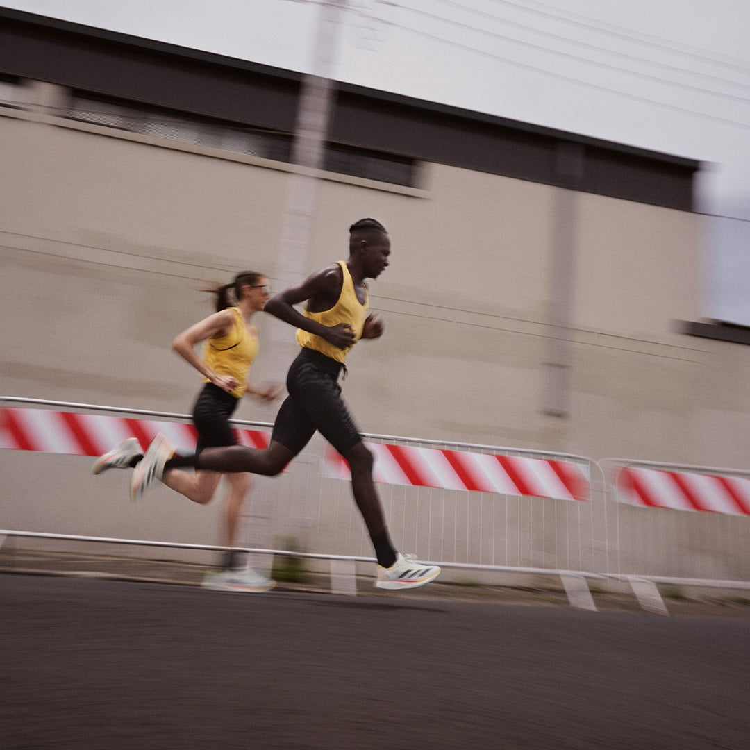 Male and female runner running fast side by side