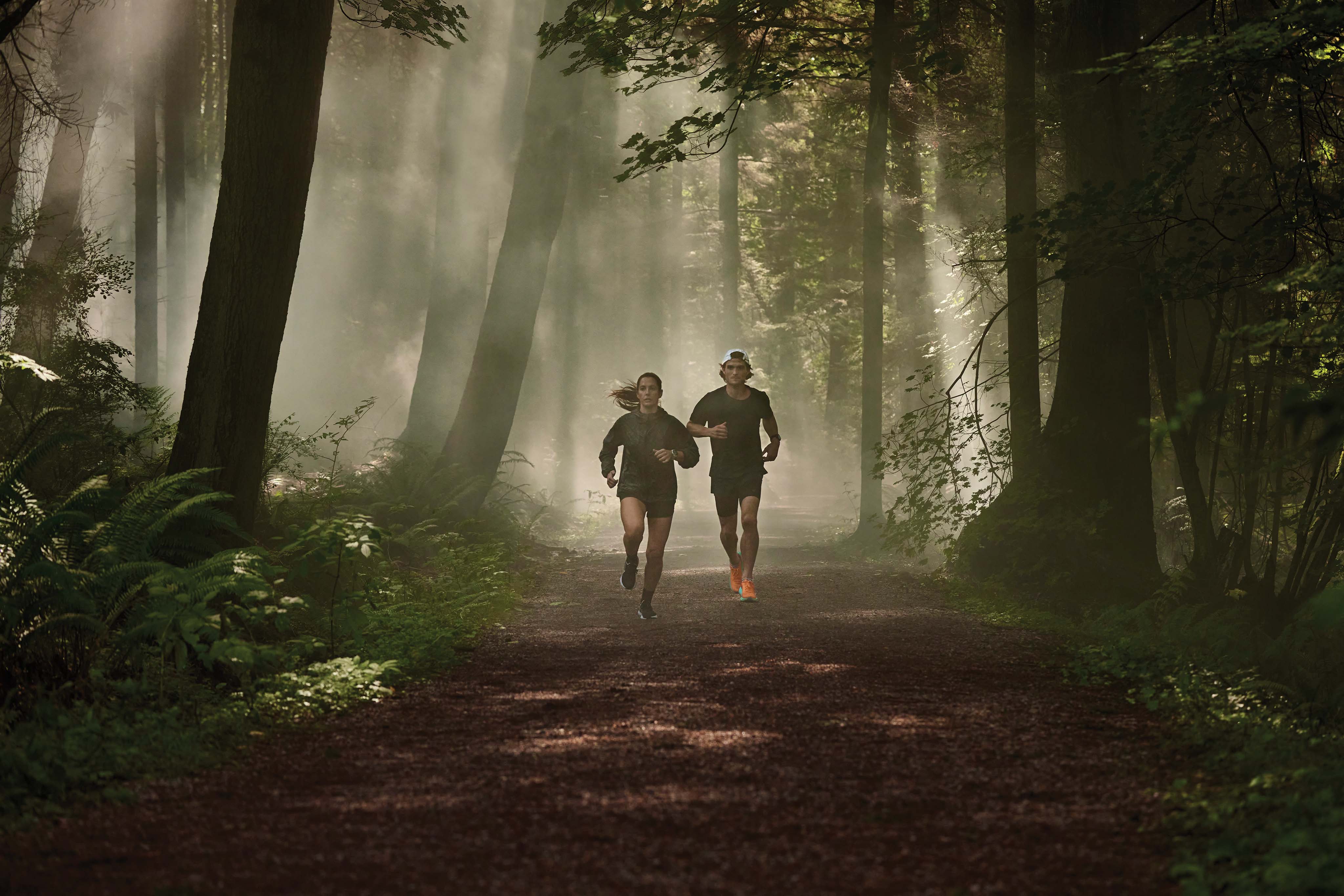 Man and woman running through woods