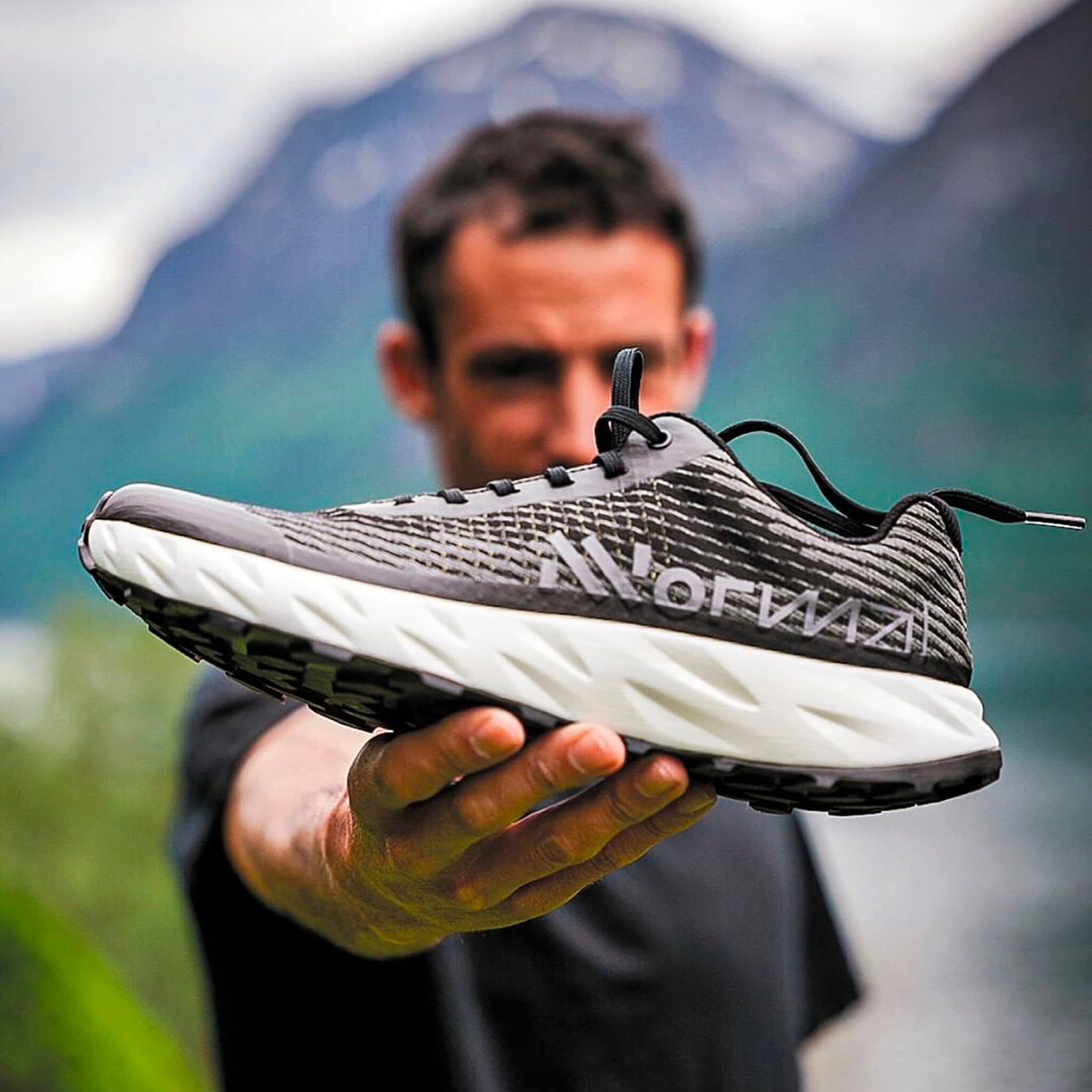 Kilian Jornet holding the NNormal Kjerag trail running shoe
