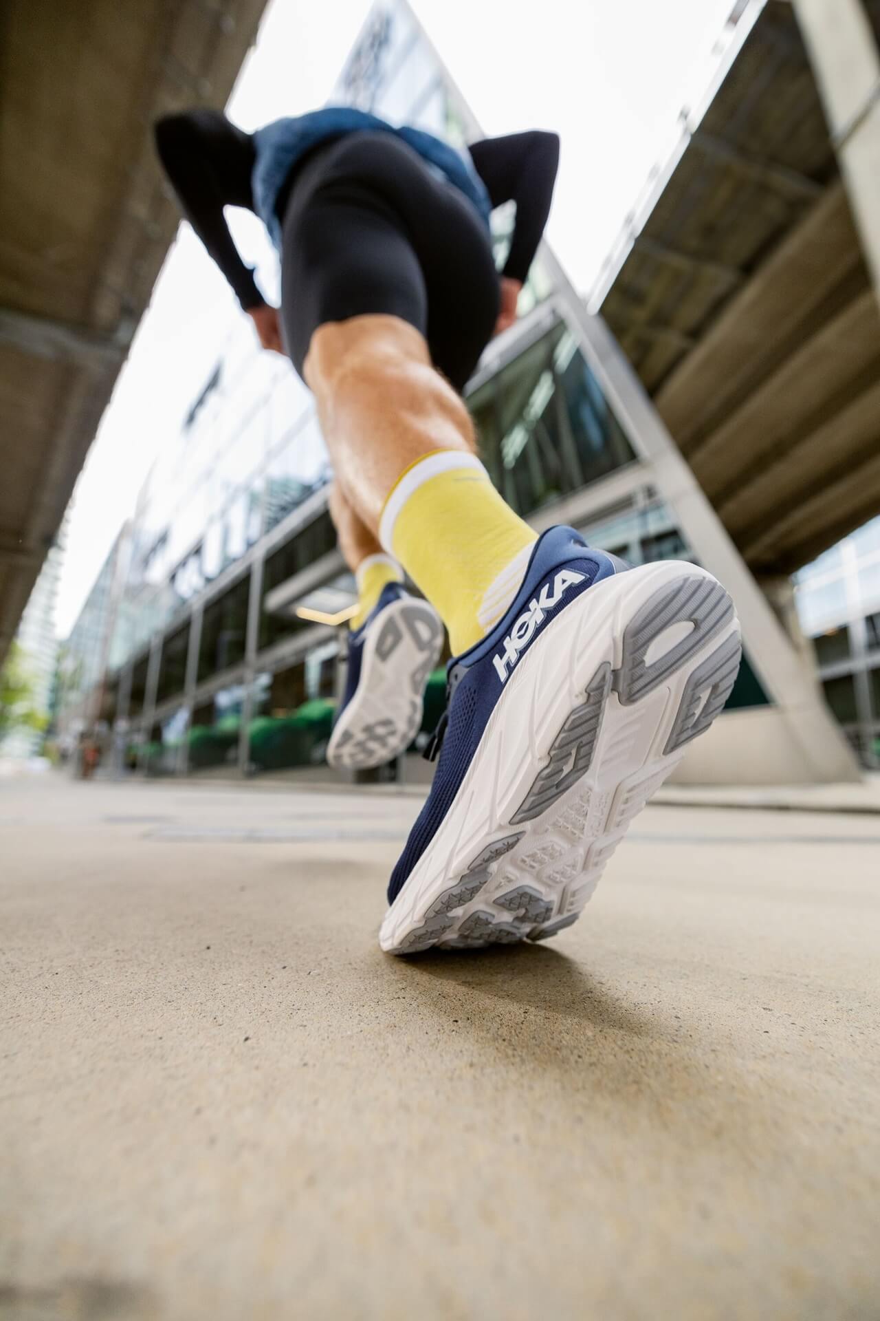 Outsole view of runner striding away in HOKA Arahi 7 running shoes