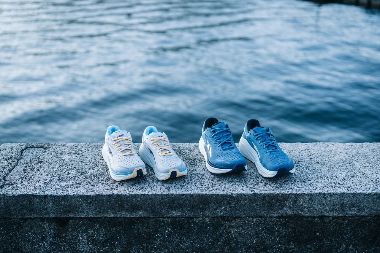 Two pairs of shoes sitting on a wall in front of the sea