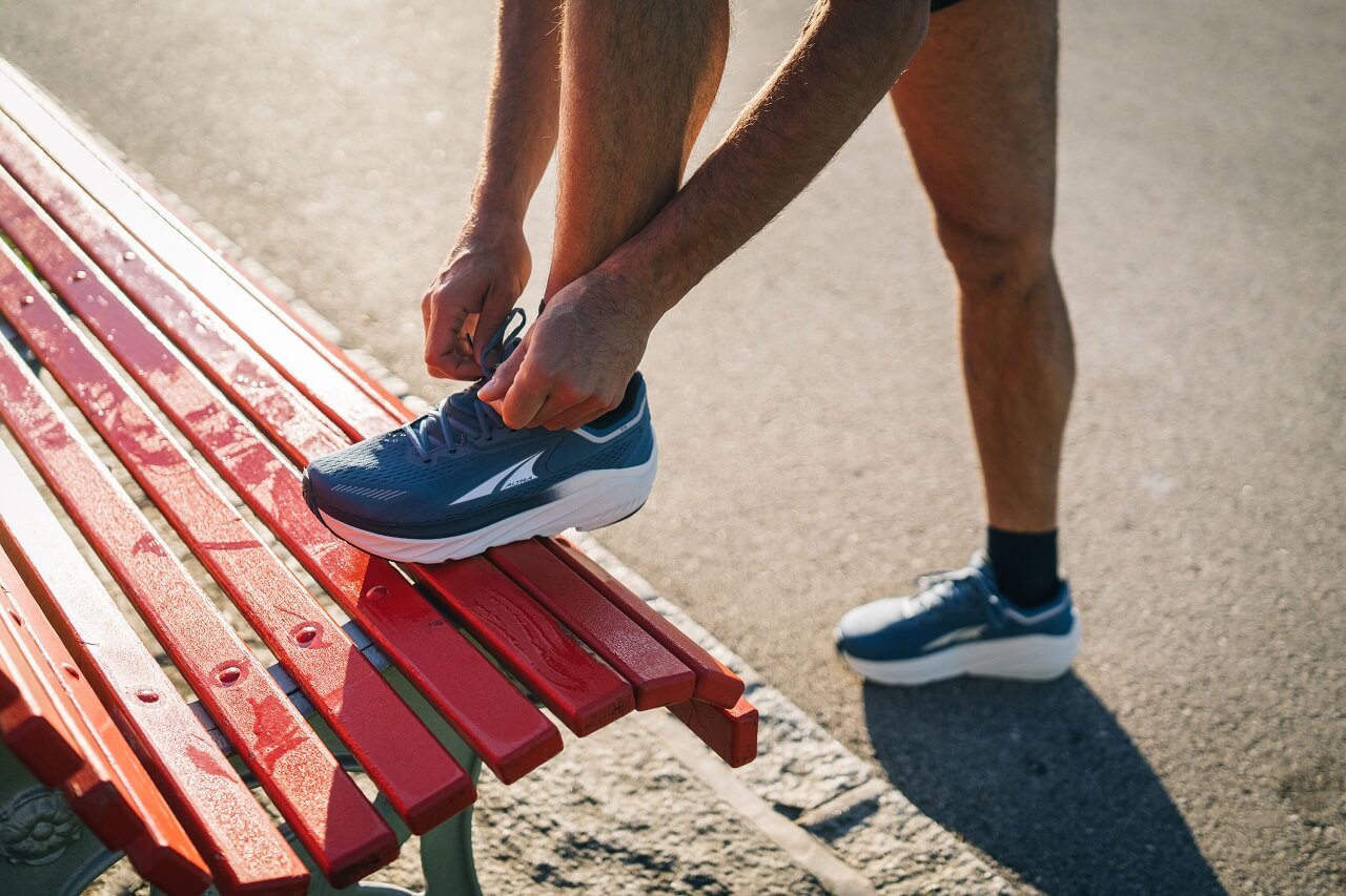 Runner tying shoe laces on bench