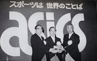 Three men in front of an ASICS sign