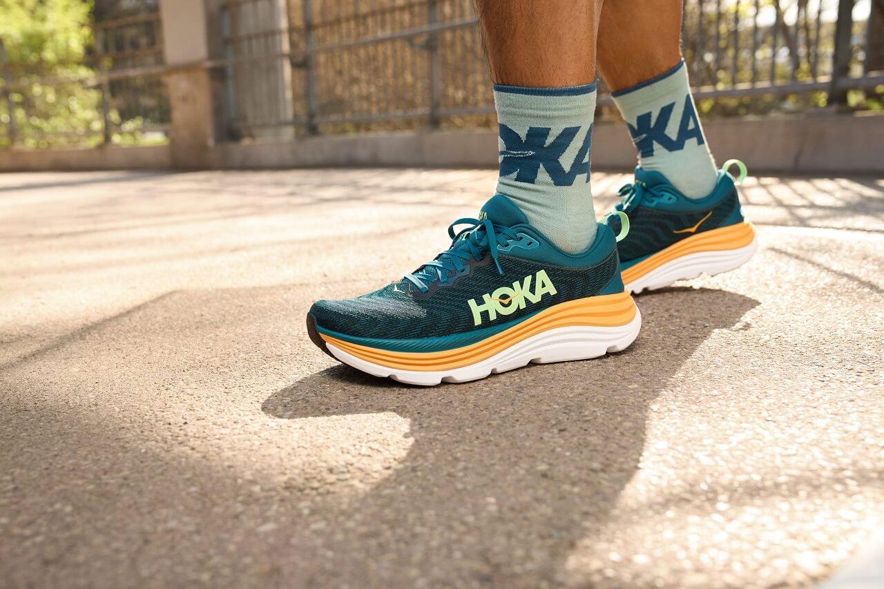 Runner standing in green HOKA Gaviota running shoes