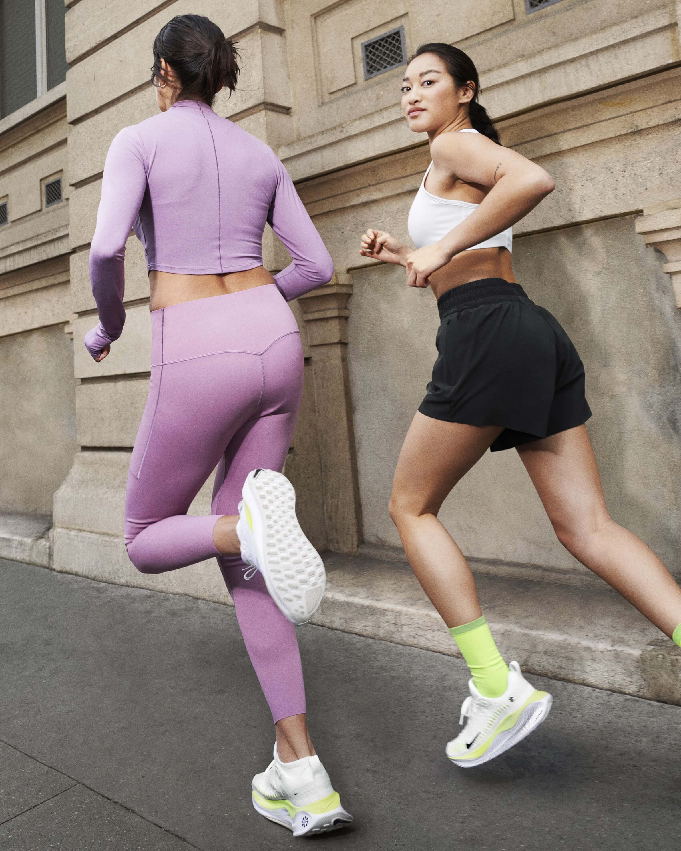 Two female runners running in city