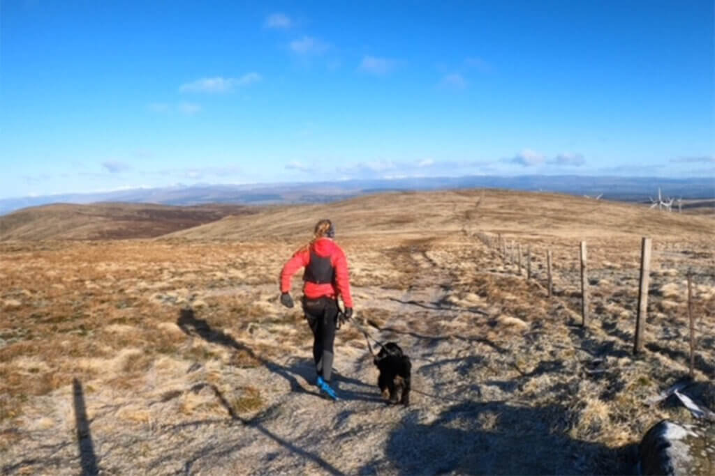 Woman running across Ochil Hills