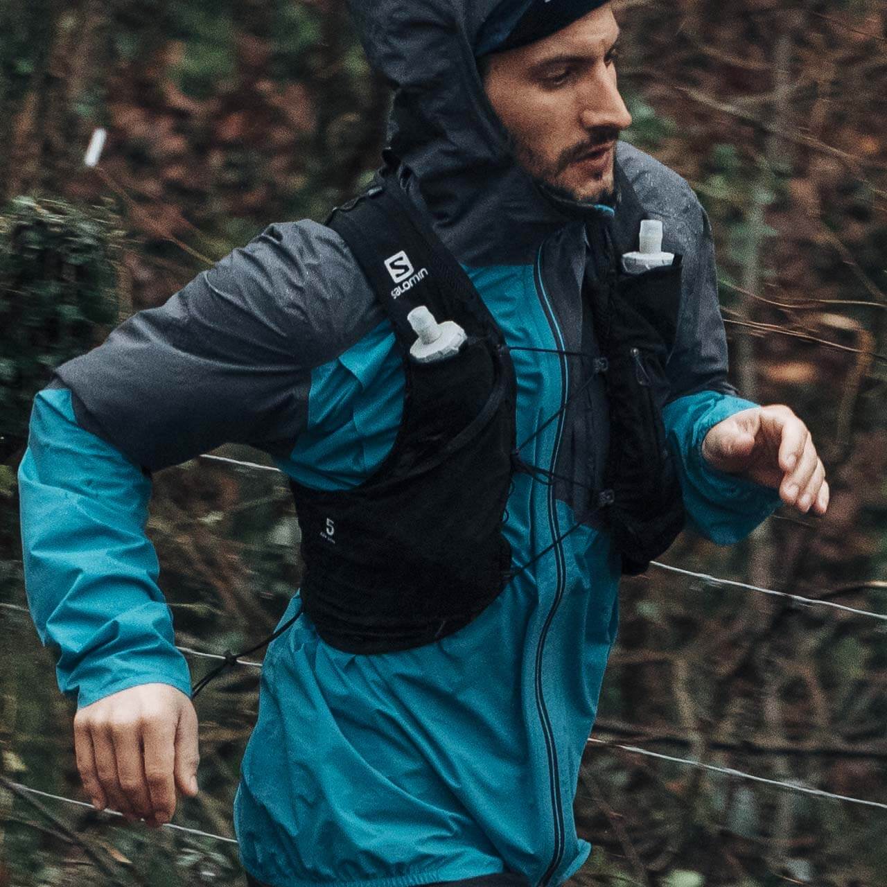 man running in the rain with Salomon pack on 