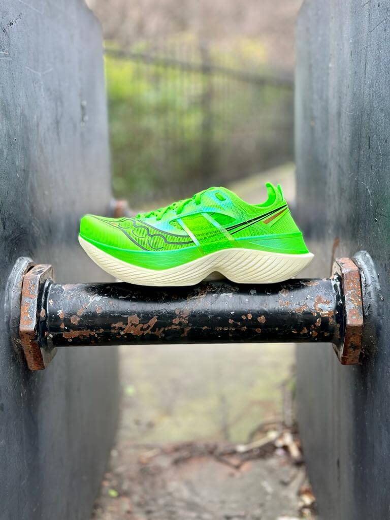 Left lateral view of Saucony Endorphin Elite road racing shoe in slime green balanced on industrial pole