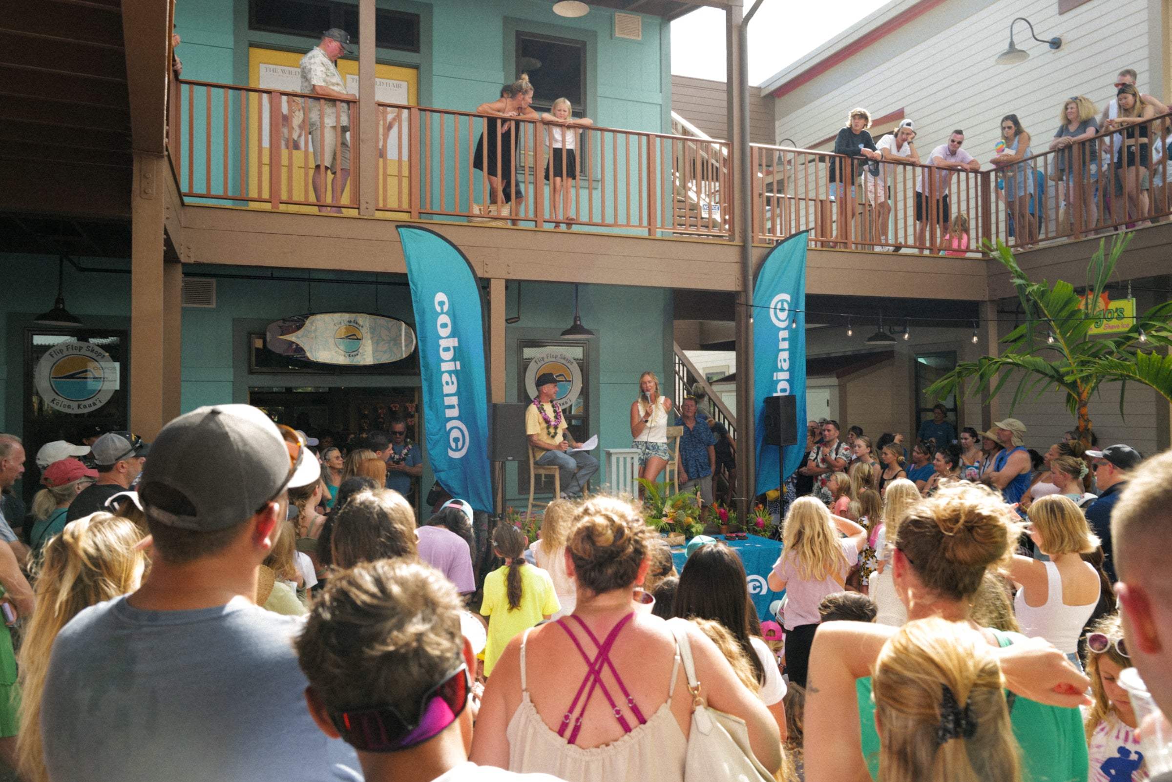 Bethany Hamilton is giving a motivational speech to a large crowd gathered at the event.